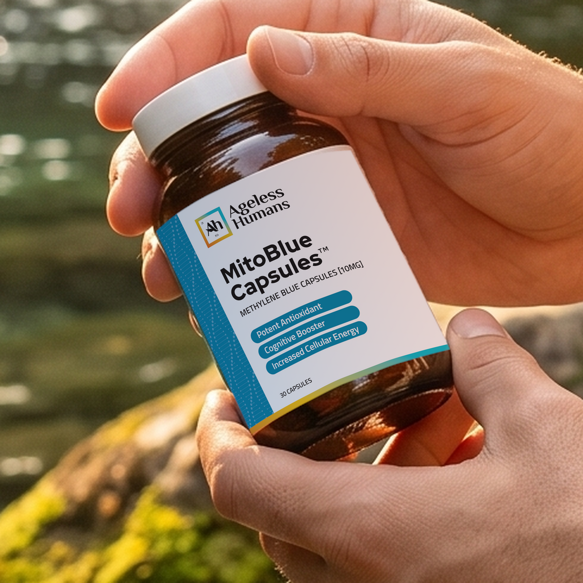 MitoBlue™ Capsules bottle held beside a stream, featuring the current production label.